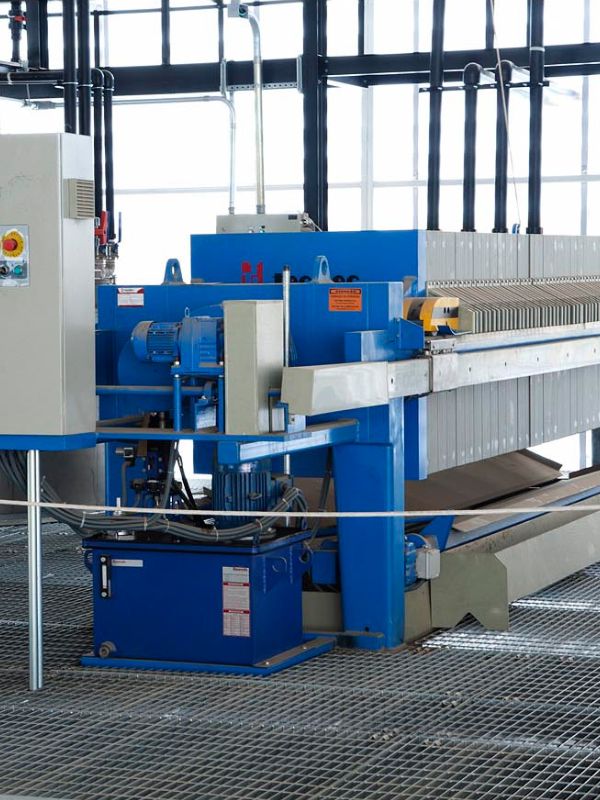 Filtro prensa industrial em operação, otimizando a separação de sólidos e líquidos no tratamento de efluentes.